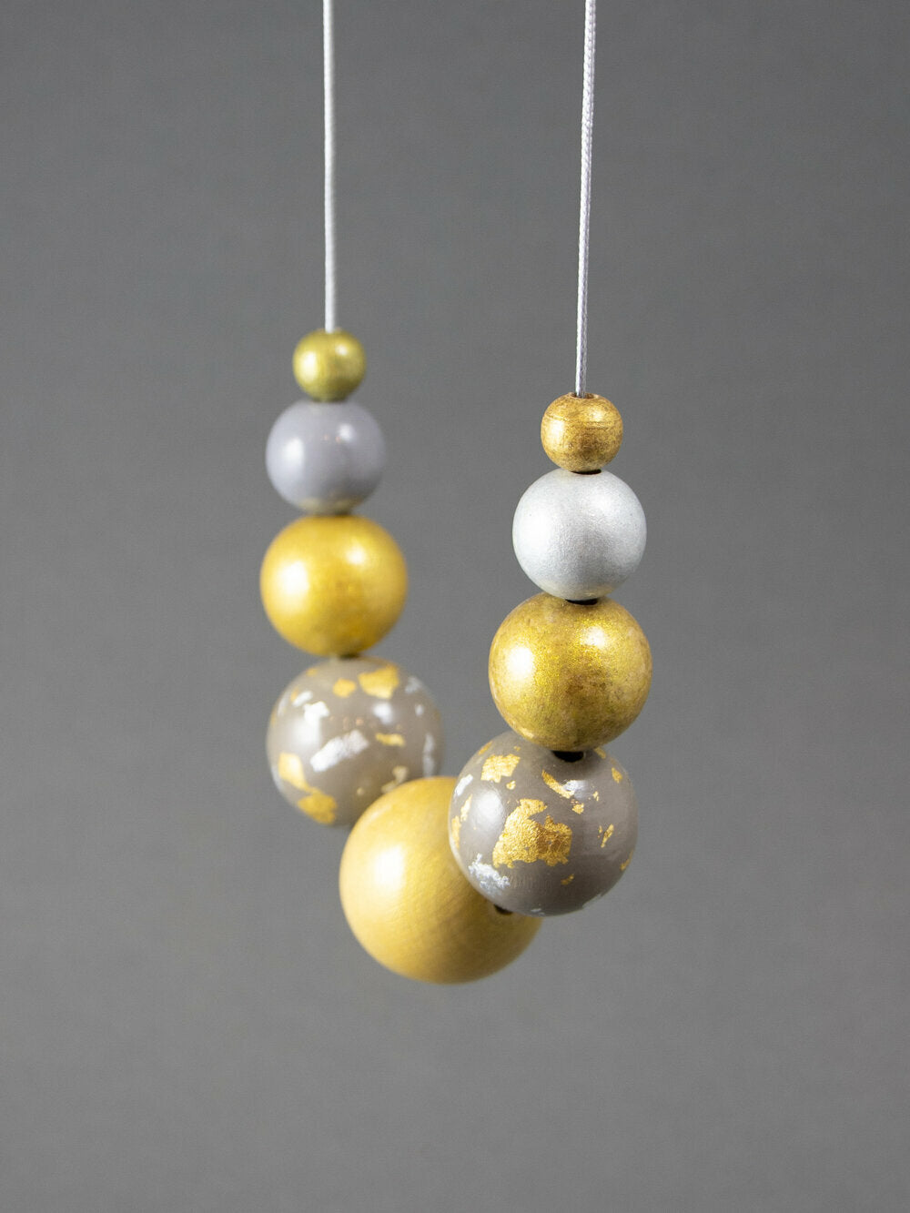 Collana di perle di legno con scaglie d'oro